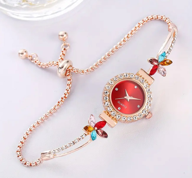 Elegant rose gold bracelet watch with red face and floral accents